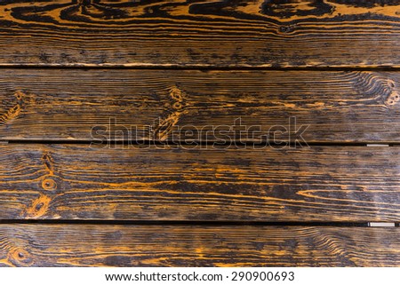 Old worn textured wood background with a strong woodgrain pattern in planks for a floor or wall covering, full frame
