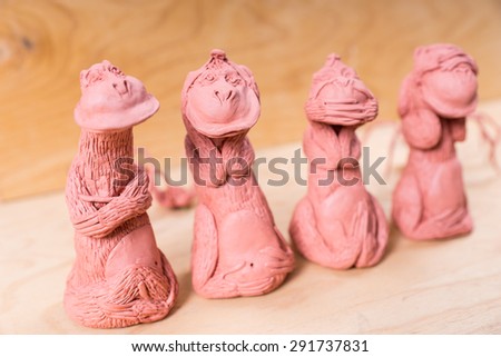 Hear no evil, speak no evil, see no evil metaphor shown by a set of handmade figurines of monkeys holding their hands over their eyes, ears and mouth and one with folded arms