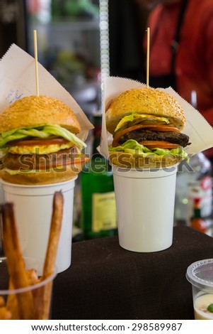 Gourmet Burger Sliders Served on Top of White Cups with French Fries
