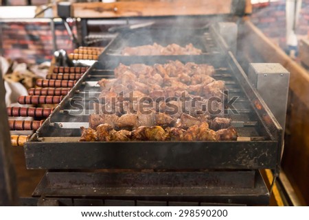 Close Up of Meat Skewers Cooking Over Hot Coals on Outdoor Smoking Barbecue Grill