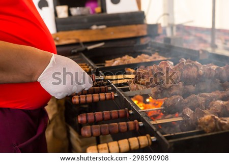 Close Up of Unidentifiable Person Cooking Meat Skewers Over Hot Coals on Outdoor Smoking Barbecue Grill