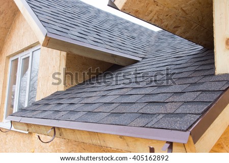 Detail of overlapping roofing tiles on a new build wooden house with dormer windows