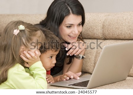 Portrait of family, mom and children enjoying indoor with a laptop