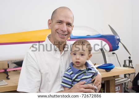 Portrait of family, mom and dad enjoying their son in the workplace