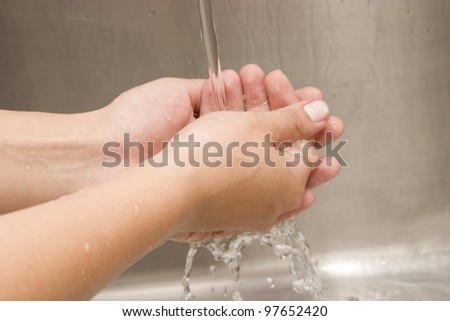 Woman Washing hands Under Running Water White Sink Chrome spout