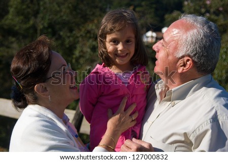 Happy Grandfather, Grandmother and grandchild, Enjoying At The Park