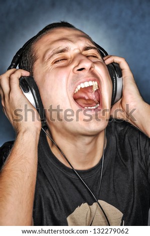 Man listen  music on headphones and scream aloud