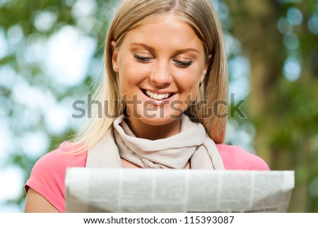 Young woman reading newspaper,Reading news