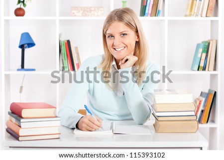 Portrait of beautiful young student with books on the table, Student