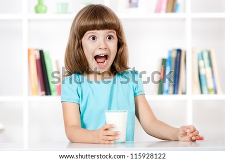 Cute little girl making a face with glass of milk in her hands,Little making a face
