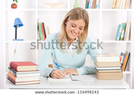 Young female student writing on a notebook,Student