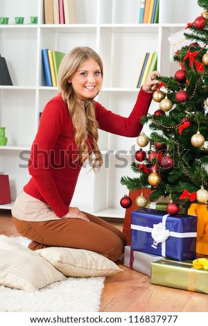 Beautiful blonde woman decorating Christmas tree,Decorating Christmas tree
