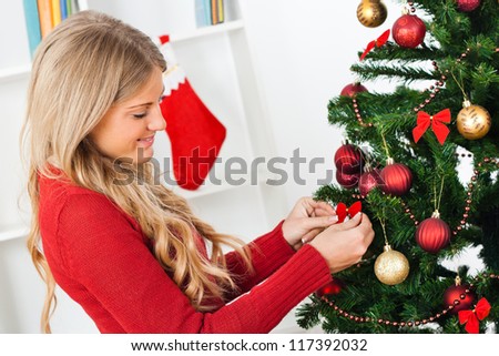Beautiful young woman decorating Christmas tree,Decorating Christmas tree