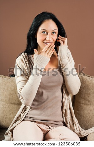 Young woman is talking on the phone and hearing surprise news,Surprised woman
