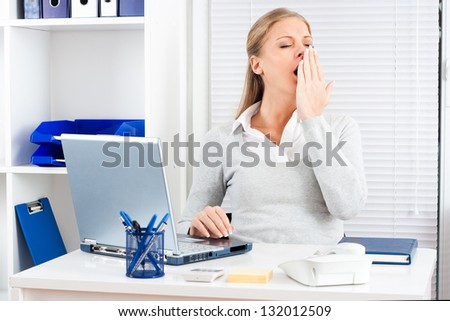 Exhausted young businesswoman yawning at work,Exhausted  businesswoman