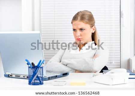 Young businesswoman is angry because of something she sees on her laptop monitor,Angry businesswoman