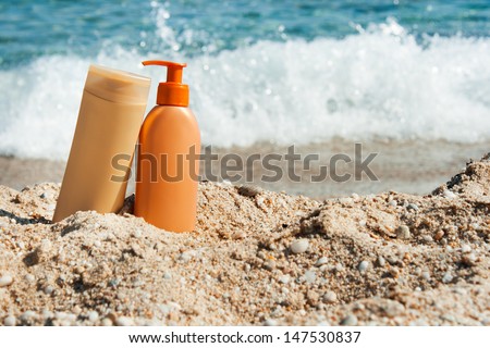 Photo of suntan lotion bottles on the beach, Sun protection