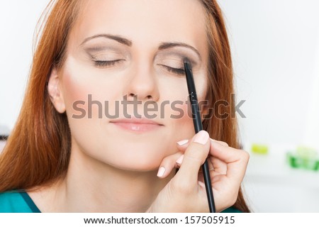 Photo of make up artist applying eyeshadow powder on a beautiful woman,Applying eyeshadow powder