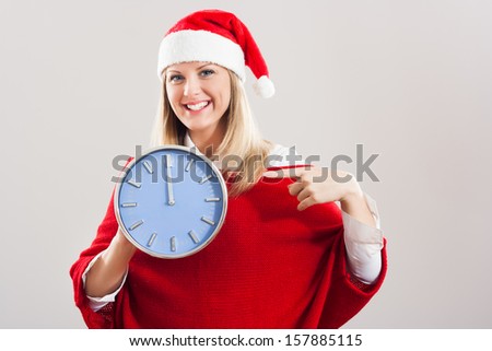 Young beautiful woman showing on the clock that  it`s midnight and a new year is here,Happy New Year!
