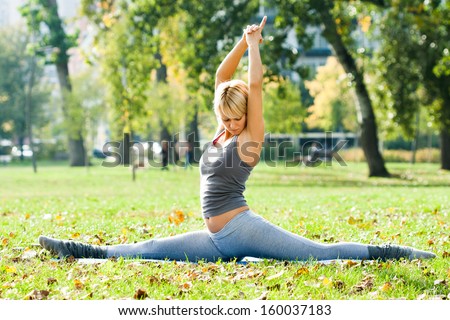 Young woman practicing yoga in the park,Yoga-Hanumanasana/Monkey Pose