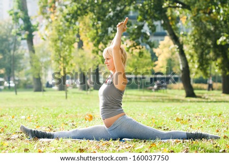 Young woman practicing yoga in the park,Yoga-Hanumanasana/Monkey Pose