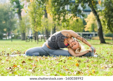 Young woman practicing yoga in the park,Yoga-Parivrtta Janu Sirsasana/Revolved Head to Knee Pose