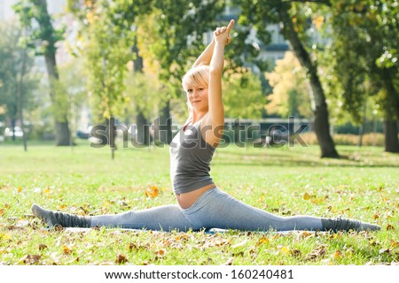 Young woman practicing yoga in the park,Yoga - Hanumanasana/Monkey Pose