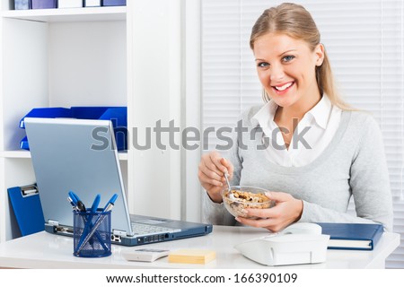 Young businesswoman is eating cereals for breakfast at work,Healthy breakfast