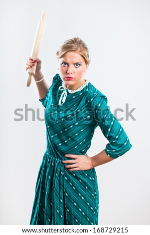Portrait of angry retro housewife holding rolling pin,Angry retro housewife