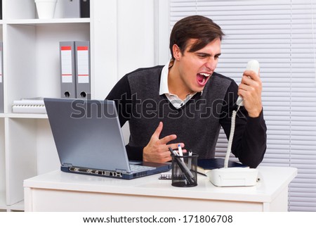 Businessman shouting on telephone at her office,Frustrated businessman
