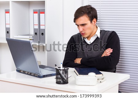 Young businessman is angry because of something he sees on his laptop monitor,Angry businessman
