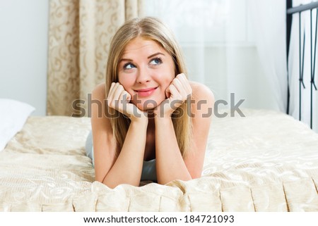 Beautiful blonde woman lying on her bed and dreaming about something,Day dreaming