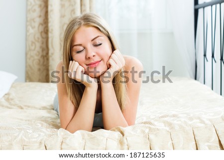 Beautiful blonde woman lying on her bed and dreaming about something,Day dreaming