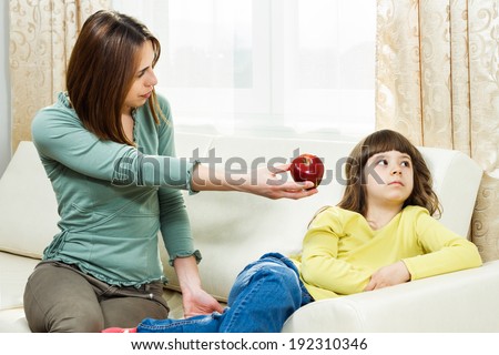 Mother is giving fruit to her daughter to eat but she is very angry,she don`t like fruit,I don`t want to eat fruit!