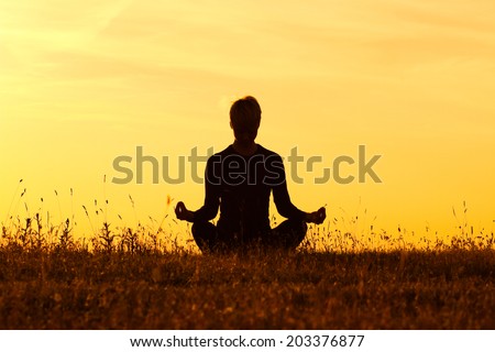 A silhouette of a woman practicing yoga,Yoga-Ardha Padmasana/Half-lotus pose