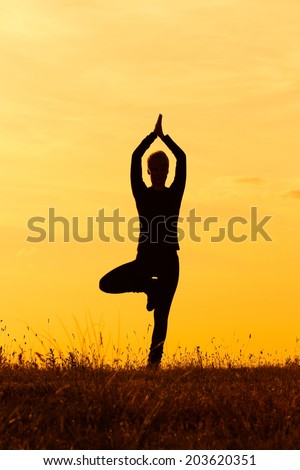 A silhouette of a woman practicing yoga,Yoga-Tree pose/Vrikshasana