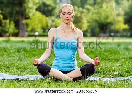 Young woman is listening music in the park and relaxing after exercise,Relaxation with music