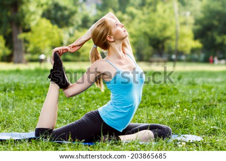Beautiful woman practicing yoga in the park,Yoga-Eka pada Rajakapotasana/Pigeon pose