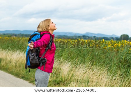 Blonde woman waist up her arms while she is standing in nature,she is feeling carefree,Peace of mind in nature
