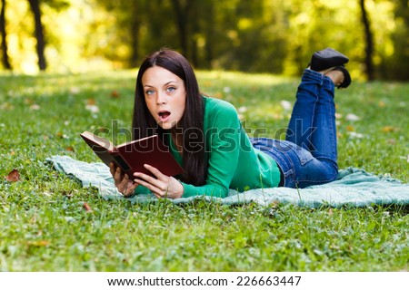 Young woman is surprised about something she had read in a book,Surprised woman