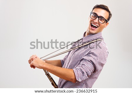 Portrait of funny handsome nerd guy pulling his suspenders.