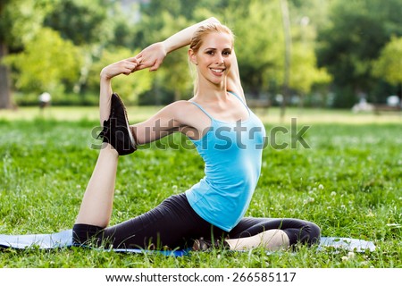 Beautiful woman practicing yoga in the park.Yoga-Eka pada Rajakapotasana/Pigeon pose