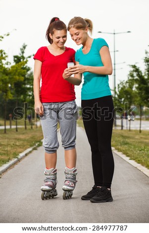 Young sporty girls are using phone.Sporty girls using phone