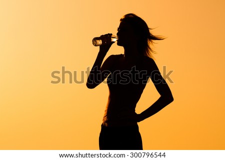 A silhouette of a woman drinking water.Refreshment