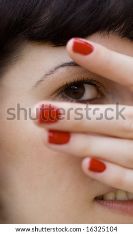 pretty brunet girl covering her face, looking through fingers