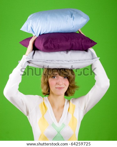 lively young woman with pillows stack on green background