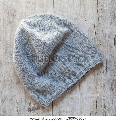 grey knitted wool beanie hat on wooden background