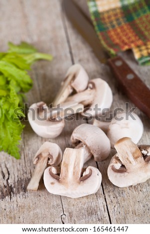 fresh champignons and old knife on old wooden table