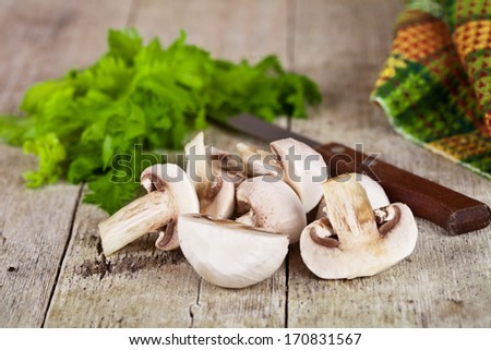fresh champignons, parsley and old knife on old wooden table