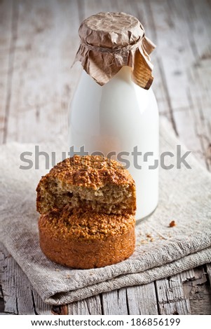 bottle of fresh milk and fresh baked bread on wooden background